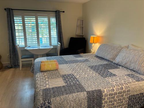 una camera da letto con un letto con un tavolo e una sedia di Malyn 122, Waterfront condo, few blocks to beach a St Pete Beach