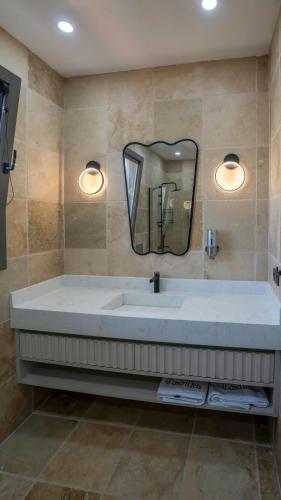 a bathroom with a large sink and a mirror at Casa Meis Villas & ESCAPES in Kaş
