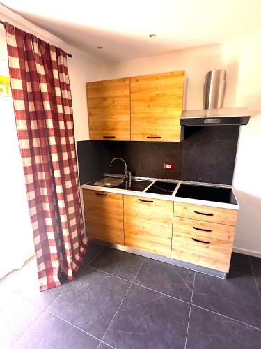a kitchen with wooden cabinets and a sink at Lussari Style Apartments in Camporosso in Valcanale