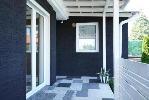 a black house with a potted plant on a porch at Villa Hoti Your Private Getaway in Mitrovicë