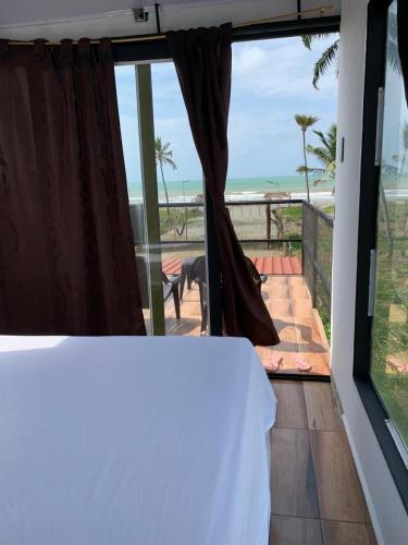 a bedroom with a view of the beach from a balcony at Hostal pura vida in San Bernardo del Viento