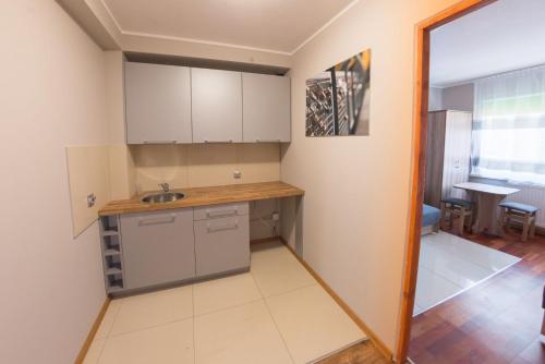 a kitchen with white cabinets and a sink at 4 Pory Roku - Węgierska Górka in Węgierska Górka