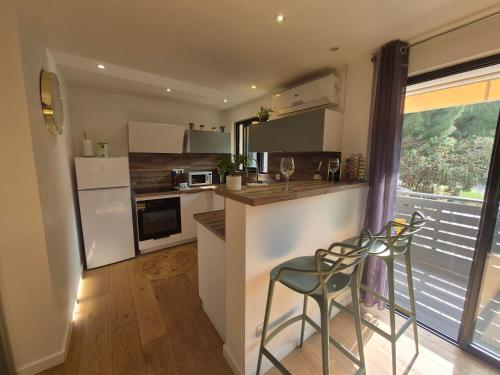 - une cuisine avec un comptoir et deux tabourets dans l'établissement Studio cosy climatisé, à Lucciana