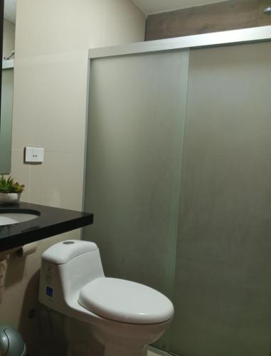 a bathroom with a white toilet and a sink at Confortable discreto y resort in Santa Cruz de la Sierra