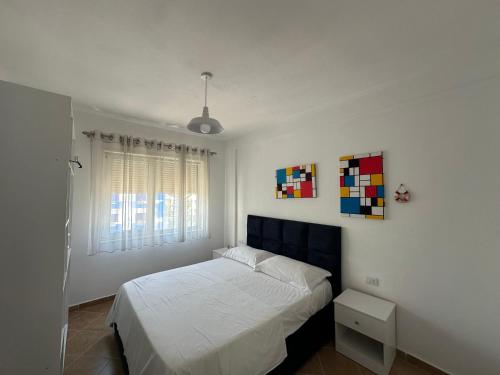a bedroom with a white bed and a window at Joni's Twin Condos (Pool&Pine View) in Golem