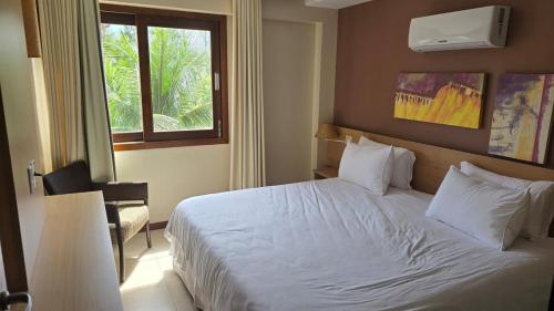 a bedroom with a white bed and a window at Beachfront Ap 314 Kariri Beach in Caucaia