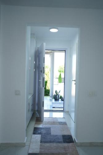 a hallway with white walls and a door with a rug at Villa Hoti Your Private Getaway in Mitrovicë