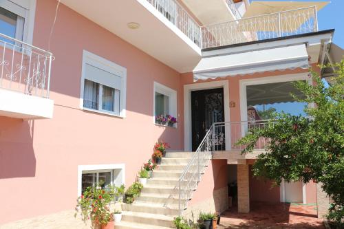 a pink house with stairs and a door at Villa Duka in Krujë