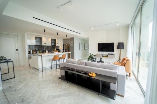 a living room with a couch and a kitchen at Exclusive and Luxurious 2BR at Wanders & Yoo in Panama City