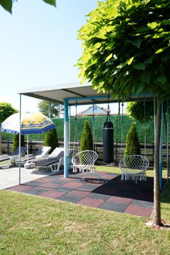 a gazebo with chairs and umbrellas on a patio at Villa Hoti Your Private Getaway in Mitrovicë
