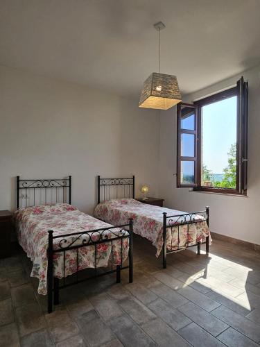 a bedroom with two beds and a window at Borgo Amarrante in Montaione
