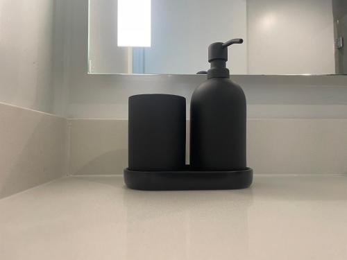 a black soap dispenser sitting on a counter in a bathroom at Downtown Miami Luxury Condo apartment in Miami