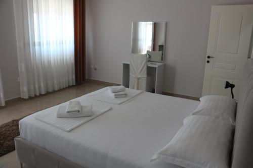 a white bed with two towels on top of it at Villa Duka in Krujë