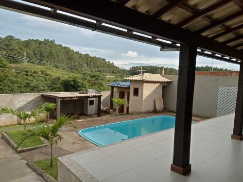 a backyard with a swimming pool and a house at Shamah Espaço in Catas Altas