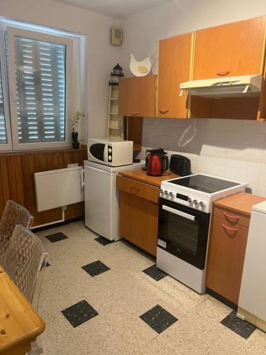 a kitchen with wooden cabinets and a white stove top oven at La bonne époque in La Celle-sous-Gouzon