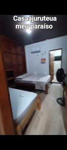 a room with two beds and a sign that reads casserole new paranoia at Casa Ajuruteua Meu Paraíso in Bragança