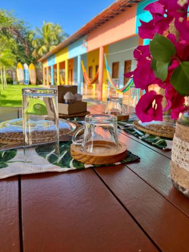 a wooden table with glasses on top of it at The Jungle, Village & Beach in Guriú
