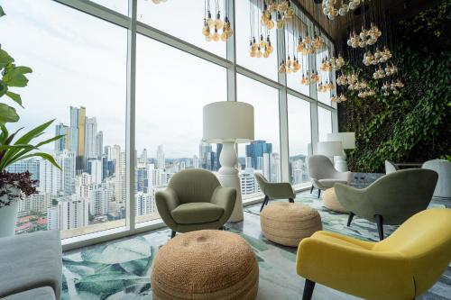 a room with chairs and tables and a large window at Exclusive and Luxurious 2BR at Wanders & Yoo in Panama City