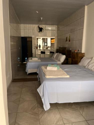 a bedroom with two beds and a bathroom at Pousada Refúgio Encantado in Goiás