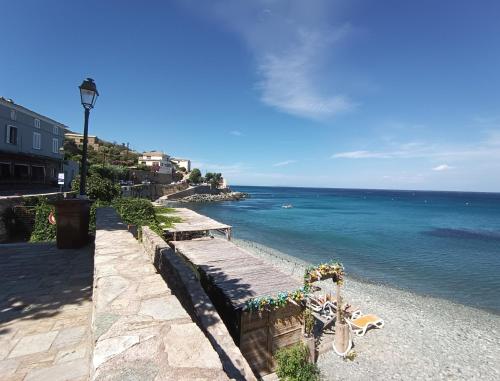 a view of the ocean from a stone wall at Cap sur la mer - casa Paoli in Brando