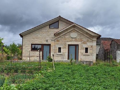 an old stone house in the middle of a field at Villa Boas House in Castro Daire