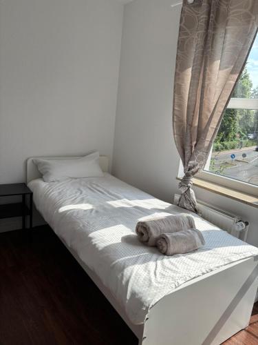 a bed with two towels on it next to a window at Monteurswohnung Lingen in Lingen