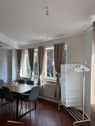 a dining room with a table and chairs and windows at Monteurswohnung Lingen in Lingen
