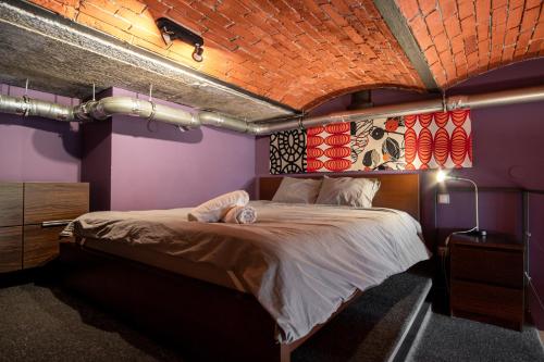 a bedroom with a large bed with a brick ceiling at Dream Aparts - Lofty Scheiblera in Łódź