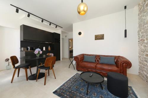ein Wohnzimmer mit einer Ledercouch und einem Tisch in der Unterkunft Sidra Heritage in Zadar