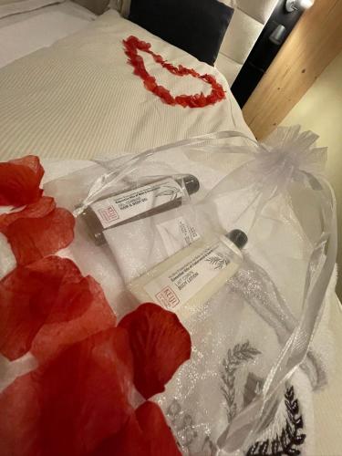 a bed with white sheets and red flowers on it at B&B Les Épis in Marche-en-Famenne