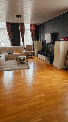 a living room with a hard wood floor and a couch at ANTWERPSESTRAAT Tomorrowland in Boom in Boom