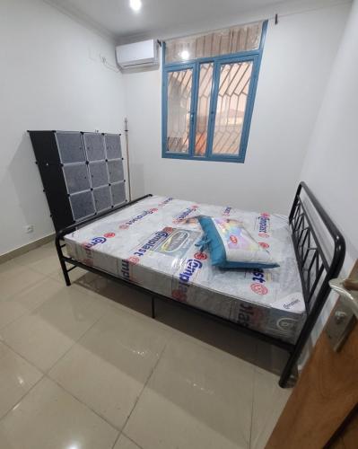a bed in the corner of a room at Appartement Amani in Kinshasa