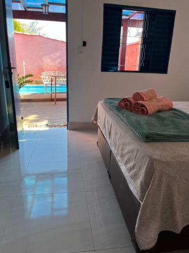 a bedroom with a bed and a view of a patio at Pousada Refúgio Encantado in Goiás