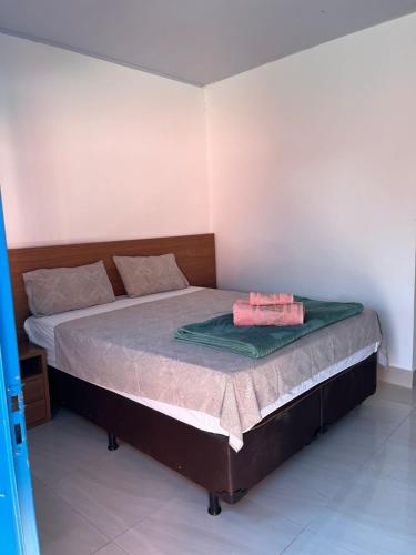 a bedroom with a bed with a green blanket on it at Pousada Refúgio Encantado in Goiás