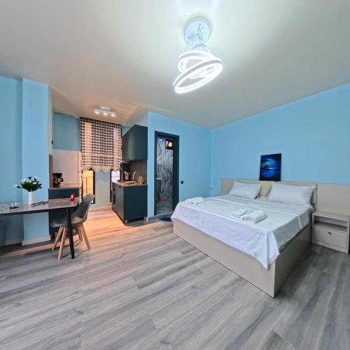 a bedroom with a bed and a desk and a kitchen at Premium apartment in Ureki