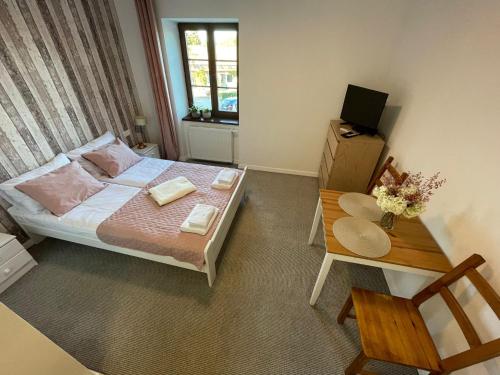 a small bedroom with a bed and a table at Apartament na Starówce in Zamość