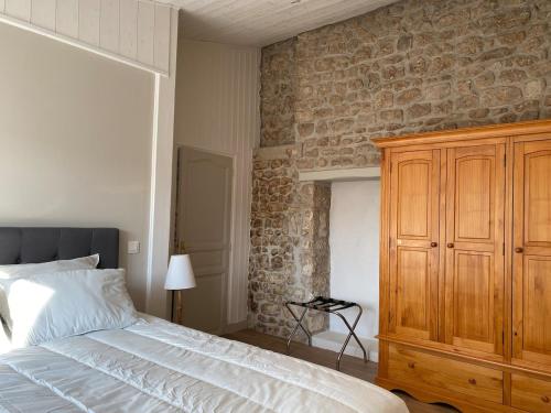 a bedroom with a bed and a stone wall at 3 étoiles entre terre et mer jolie maison in Saint-Just