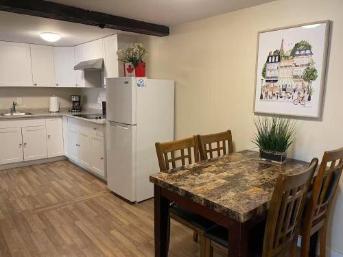 a kitchen with a table and a white refrigerator at Two bedroom in downtown in Charlottetown