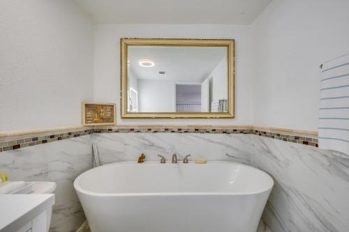 Un baño blanco con un gran espejo y una bañera. en 3 Mi to Beach Hollywood Studio with Yard!, en Hollywood