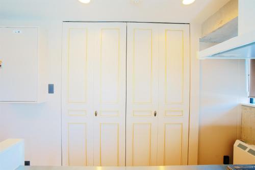 a closet with white doors in a kitchen at HOTEL Viviana in Naha