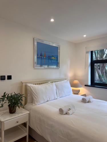 a bedroom with a white bed with towels on it at 1 bedroom apartment - The Olive Tree in Southampton