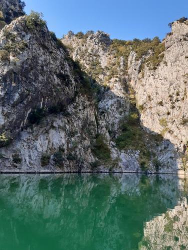 a mountain reflecting in the water of a river at Wooden Villas Karme in Koman