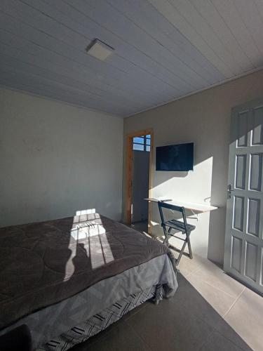 a bedroom with a bed and a desk in it at New hotel in Alegrete