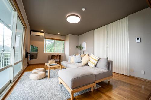a living room with a couch and a table at 貸切温泉宿 Shiny inn Kirishimaシャイニーイン霧島 in Kirishima