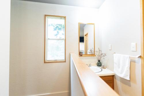 a bathroom with a sink and a mirror at 貸切温泉宿 Shiny inn Kirishimaシャイニーイン霧島 in Kirishima