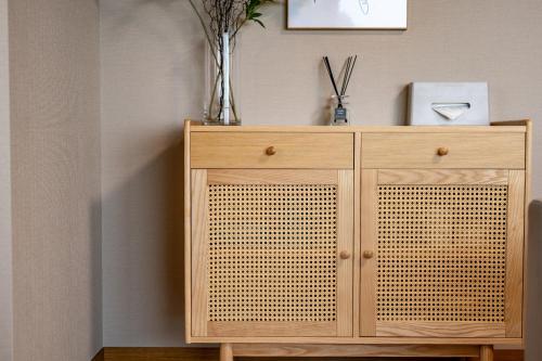 a wooden cabinet with a vase on top of it at 貸切温泉宿 Shiny inn Kirishimaシャイニーイン霧島 in Kirishima