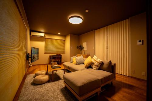 a living room with a couch and a table at 貸切温泉宿 Shiny inn Kirishimaシャイニーイン霧島 in Kirishima