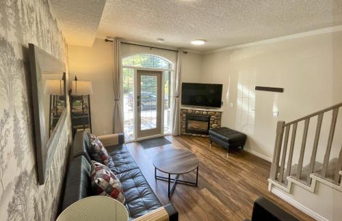 a living room with a couch and a table at Renovated Chalet at Mystic Springs, Mountain Views, Pets Welcome! in Canmore