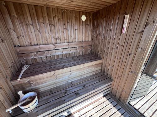 an inside of a wooden sauna with a toilet at Mazurski Relaks in Urowo