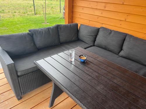 a gray couch and a table with a drink on it at Mazurski Relaks in Urowo